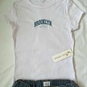 white tee w blue embroidered letters